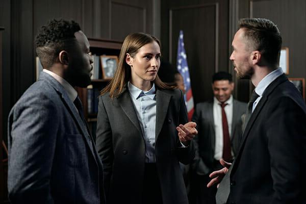 three people talking in board room setting